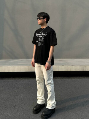 Men's off-white snap-hem utility flare jeans front full-body streetwear outfit with black graphic t-shirt and platform boots
