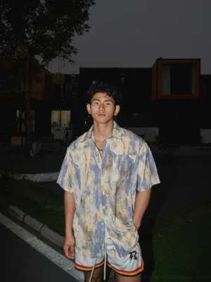 Full front view of an abstract marbled print short-sleeve button-up shirt in vintage beige brown and muted purple tones styled with athletic shorts in Korean streetwear fashion