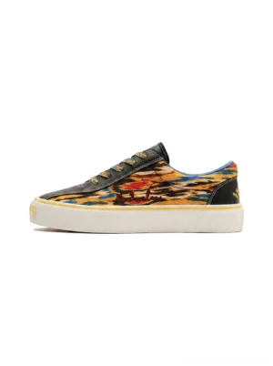 Yellow abstract print canvas skate shoes with black toe cap, black heel tab, and off-white rubber outsole shown in a side-front close-up