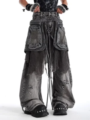 Charcoal ash abyss mesh layered baggy cargo jeans shown in a front three-quarter view with washed distressed denim, oversized pockets, mesh panels, and wide legs