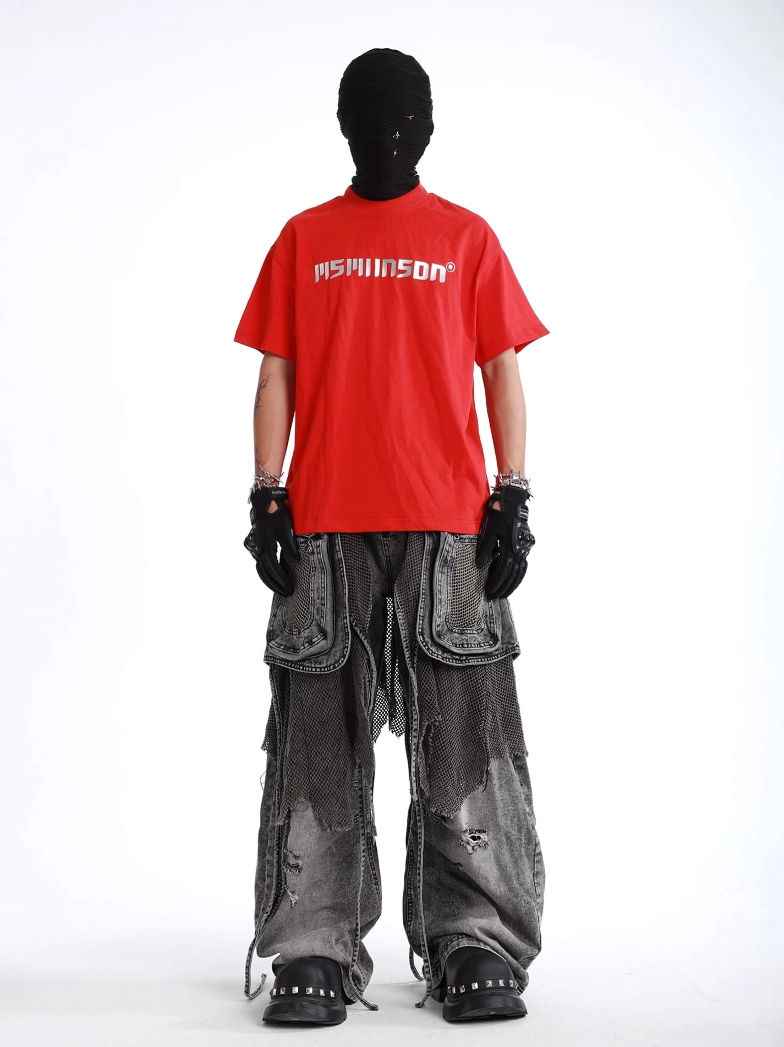 Charcoal ash baggy mesh layered cargo jeans styled with a red graphic T-shirt, featuring faded distressed denim, oversized pockets, and studded boots