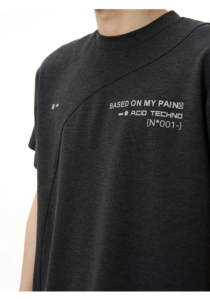 Close-up view of dark grey Acid Techno T-shirt showing Based on My Pain chest graphic and diagonal asymmetric seam