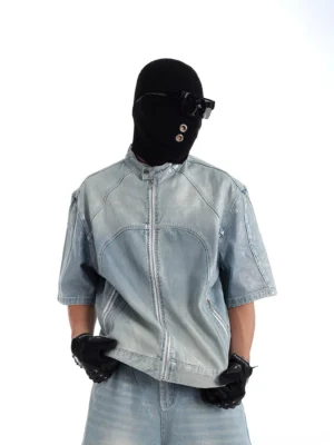 Three-quarter view of relaxed boxy acid wash denim moto jacket with short sleeves, side zip pockets and faded blue streetwear finish