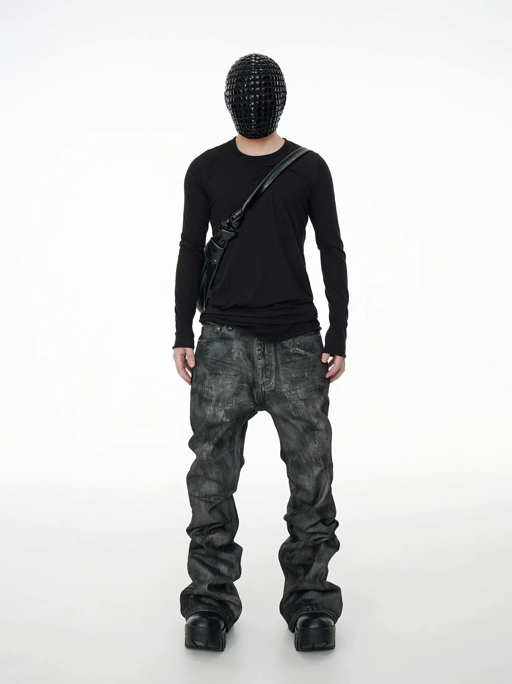 Full rear outfit view featuring streamlined acid wash coated stacked jeans with a black top, crossbody leather bag, and black leather shoes