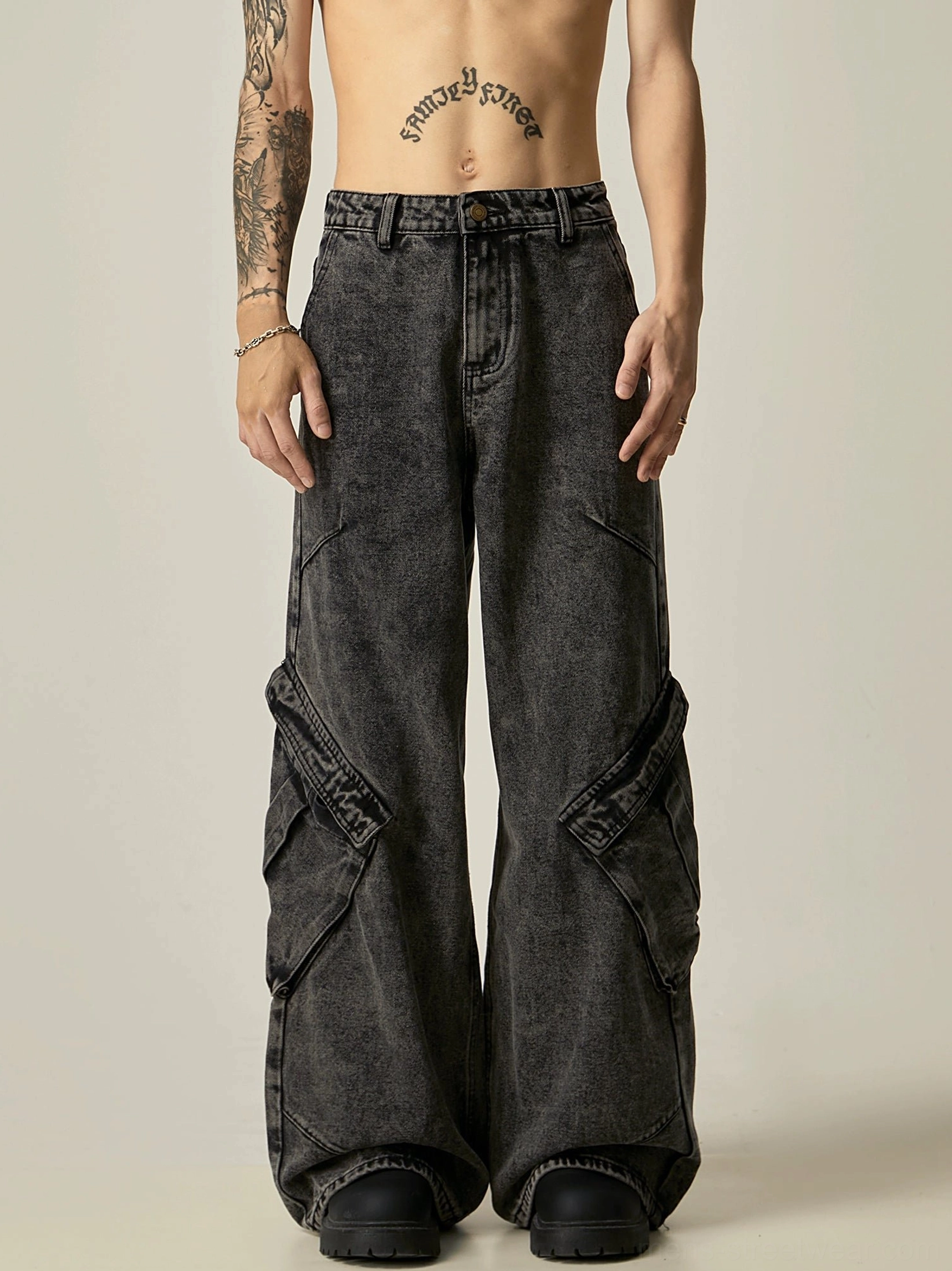 Full front view of acid-washed black cargo wide-leg jeans showing the button-fly waistband, oversized silhouette, and multi-panel utility pocket design