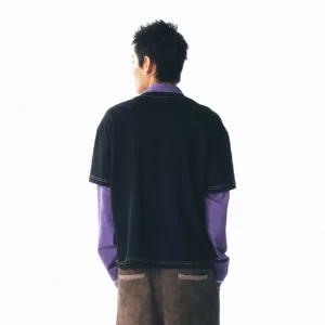 Back view of a two-in-one black layered long sleeve tee with exposed purple sleeves and contrast hem stitching