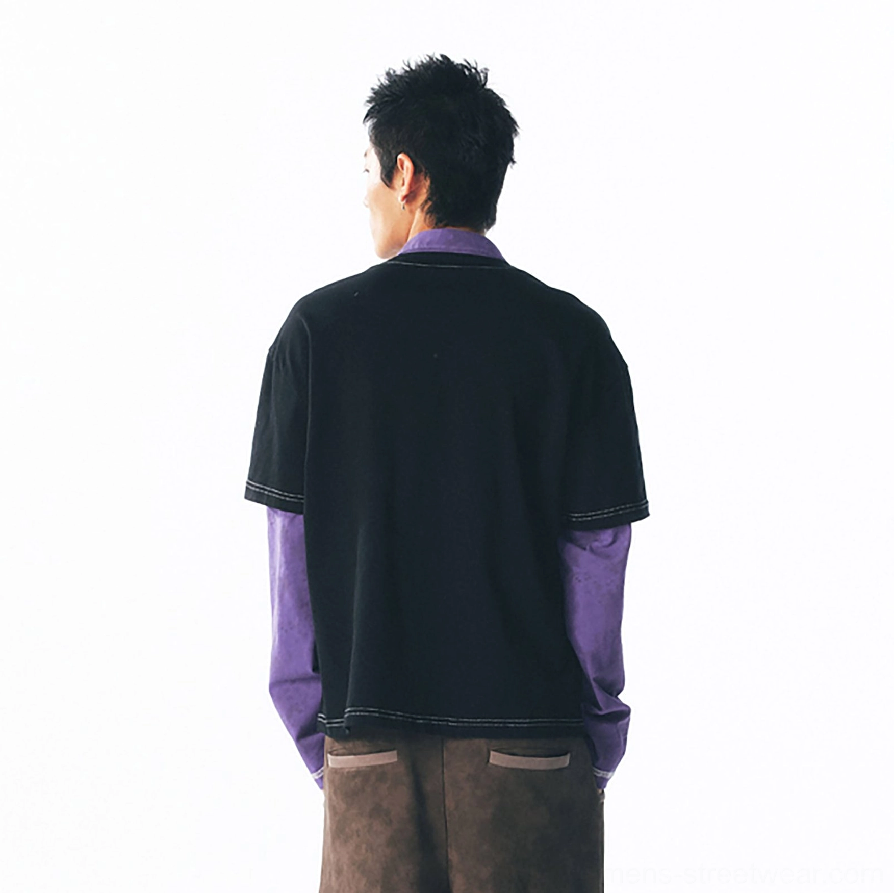 Back view of a two-in-one black layered long sleeve tee with exposed purple sleeves and contrast hem stitching