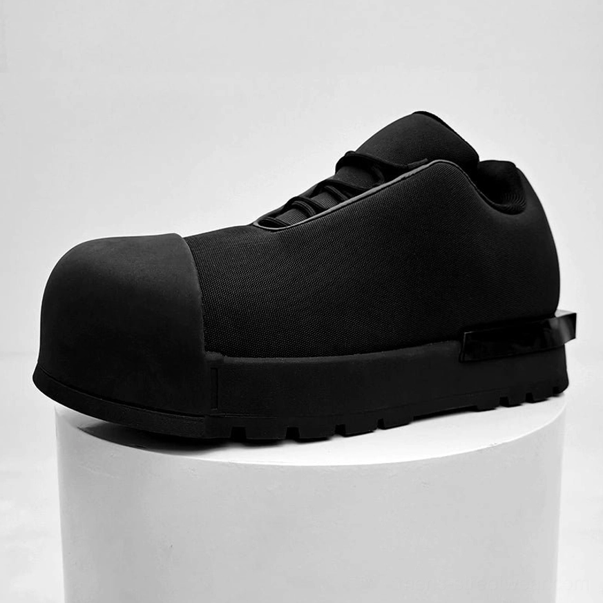 All-black chunky platform sneakers with oversized rounded toe, thick lug sole, glossy heel accent, and minimalist streetwear design