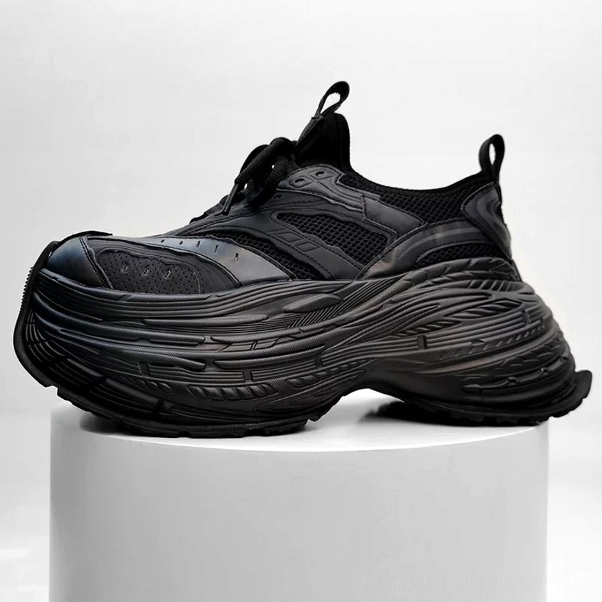 All black functional chunky platform outdoor sneakers with matte textured upper and stacked serrated rubber sole
