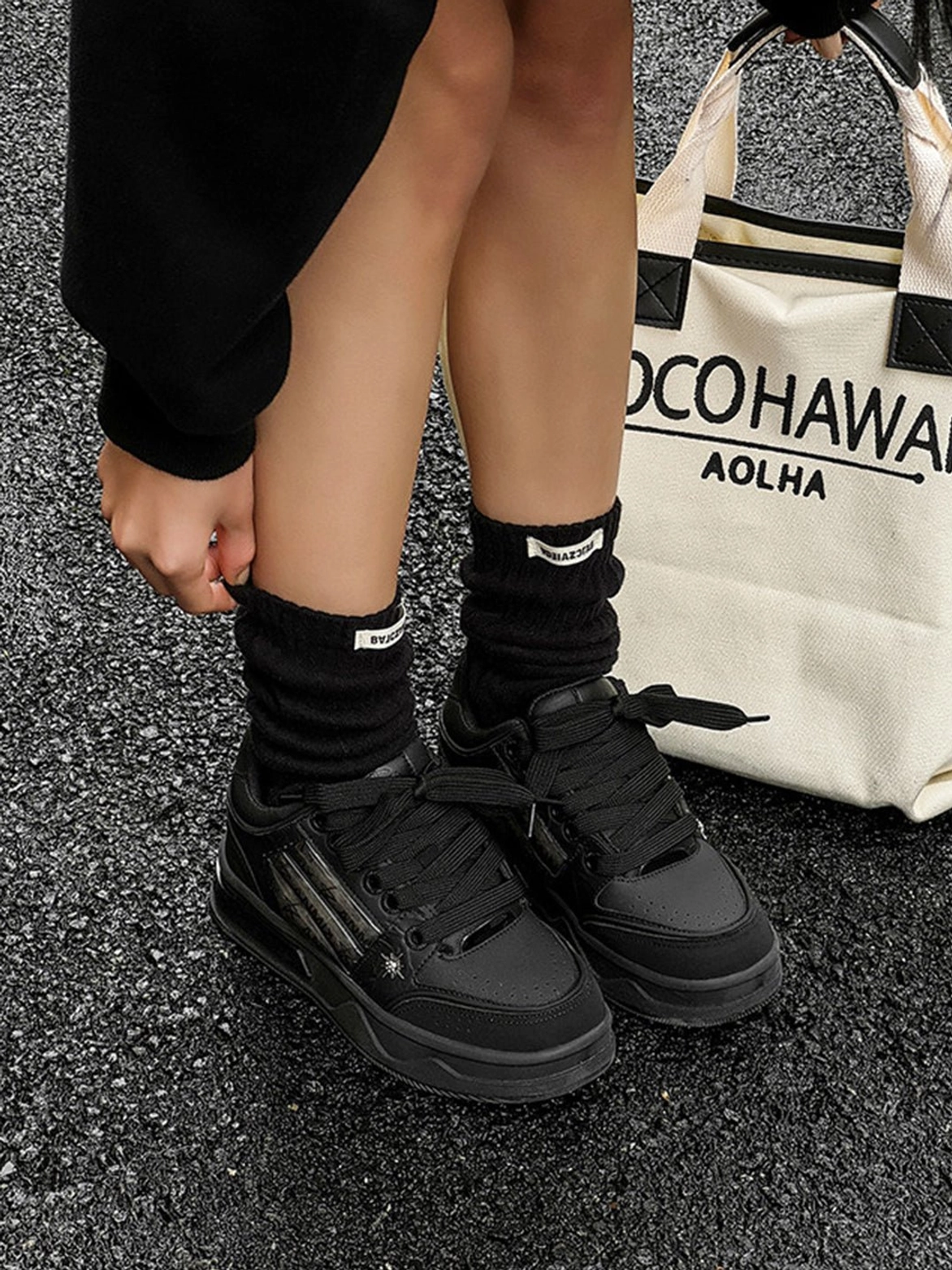 All black gothic streetwear sneakers with silver striped details and chunky platform soles styled with black socks and oversized casual clothing