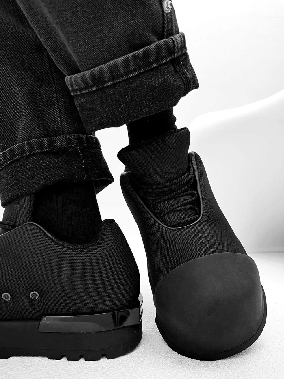 All-black minimalist platform sneakers with thick sole, metal heel studs, glossy heel accent, and modern Korean streetwear styling
