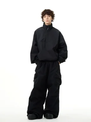 Full-body front view of an all-black oversized techwear windbreaker and wide-leg cargo pants streetwear set on a male model