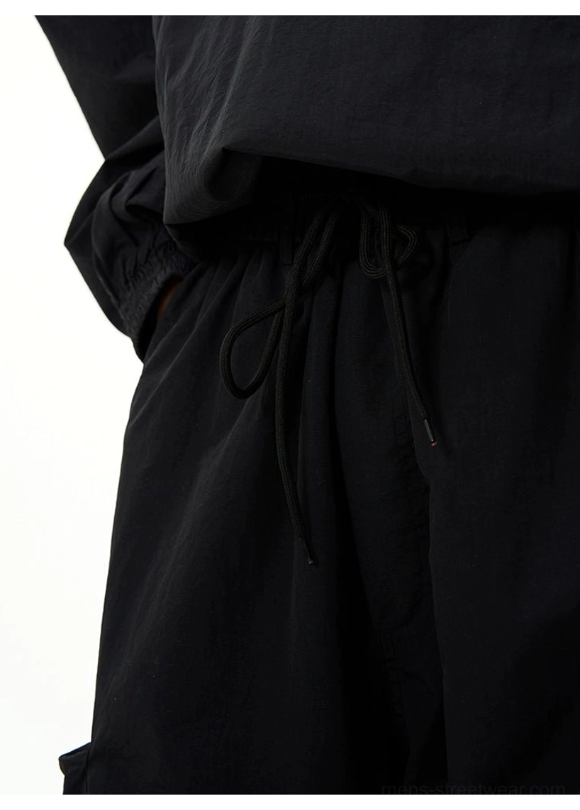 All-black oversized techwear windbreaker and wide-leg cargo pants set for modern Korean streetwear styling