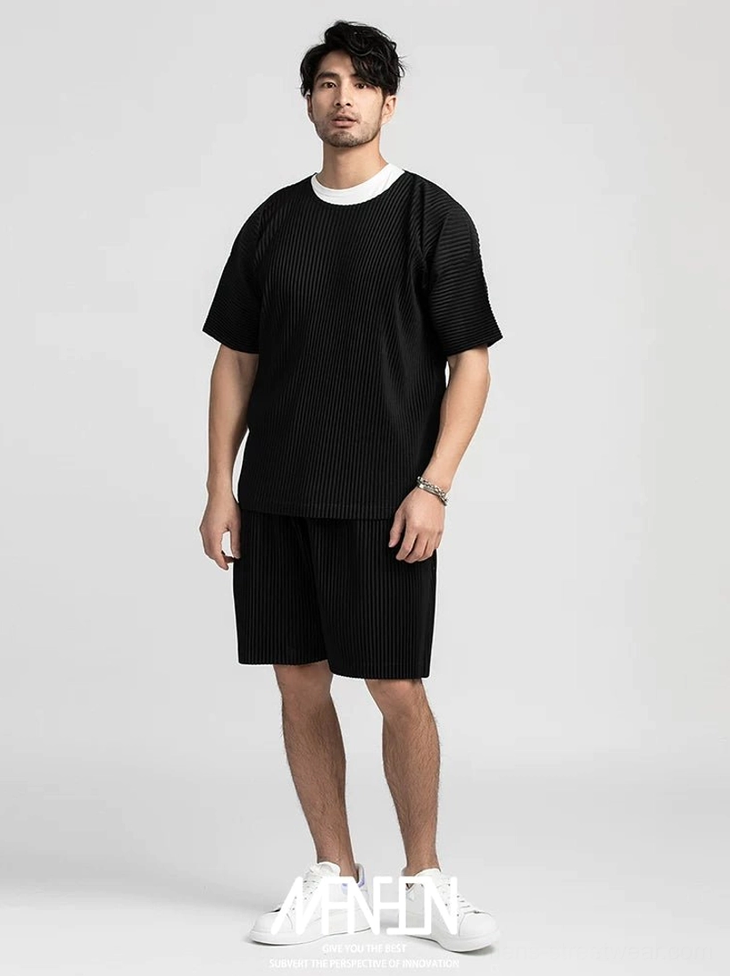 All black pleated shorts and matching pleated crew neck tee styled as a minimalist streetwear set