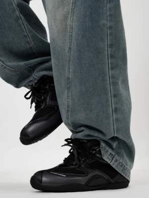 All black retro low top running sneakers with breathable mesh panels styled with washed denim and black streetwear jacket