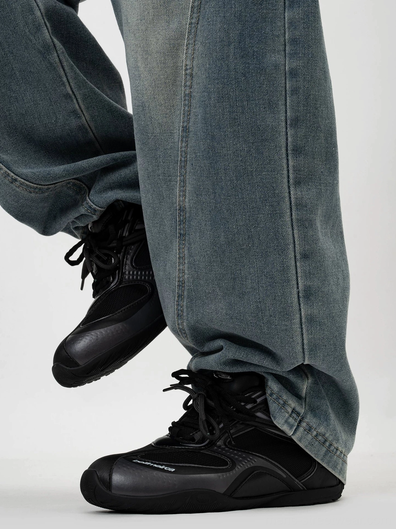 All black retro low top running sneakers with breathable mesh panels styled with washed denim and black streetwear jacket
