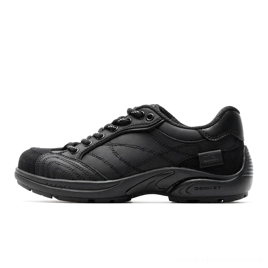 All-black retro runner sneakers with matte leather-look upper, black round laces, crisscross stitching, and full black rubber outsole