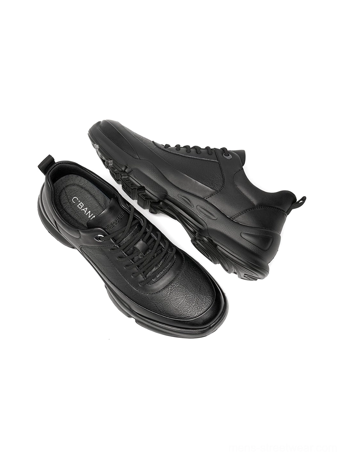 Three-quarter rear view of all-black chunky sneakers showing heel tab leather-look texture and sole profile