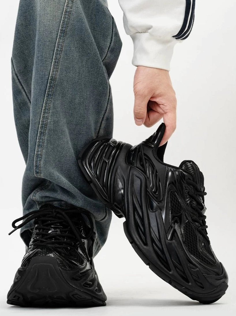 All-black techwear chunky sneakers featuring lace-up closure, padded collar, rear pull tab, glossy sculpted ridges, breathable mesh, and thick elevated platform sole