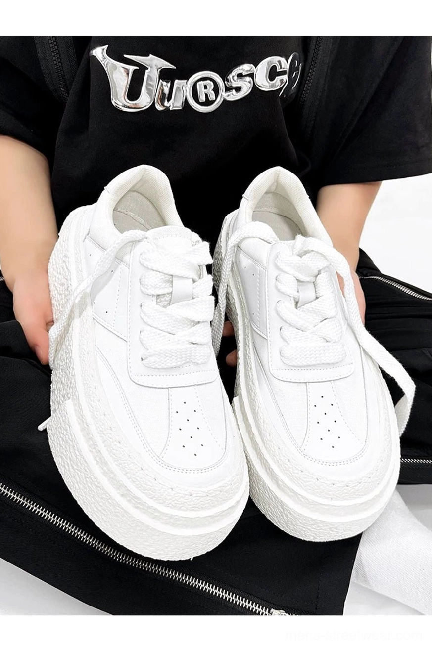 All-white chunky platform sneakers with perforated toe box wide laces and textured rubber soles