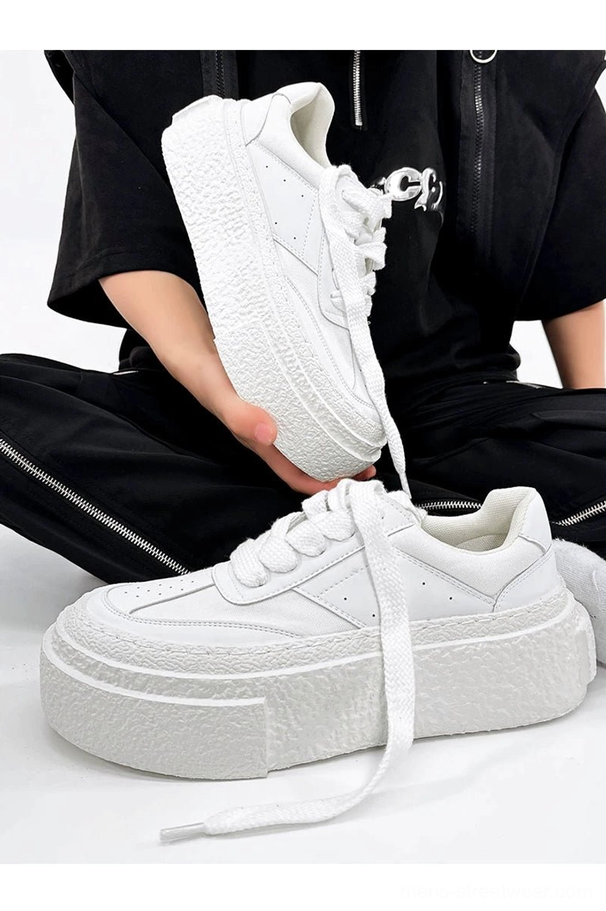 All-white chunky streetwear sneakers with wide flat laces and thick textured platform rubber soles