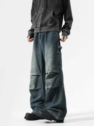 Ancient blue vintage washed carpenter balloon jeans shown in a three-quarter front full-body streetwear outfit with faded denim, pleated knees, and wide stacked legs