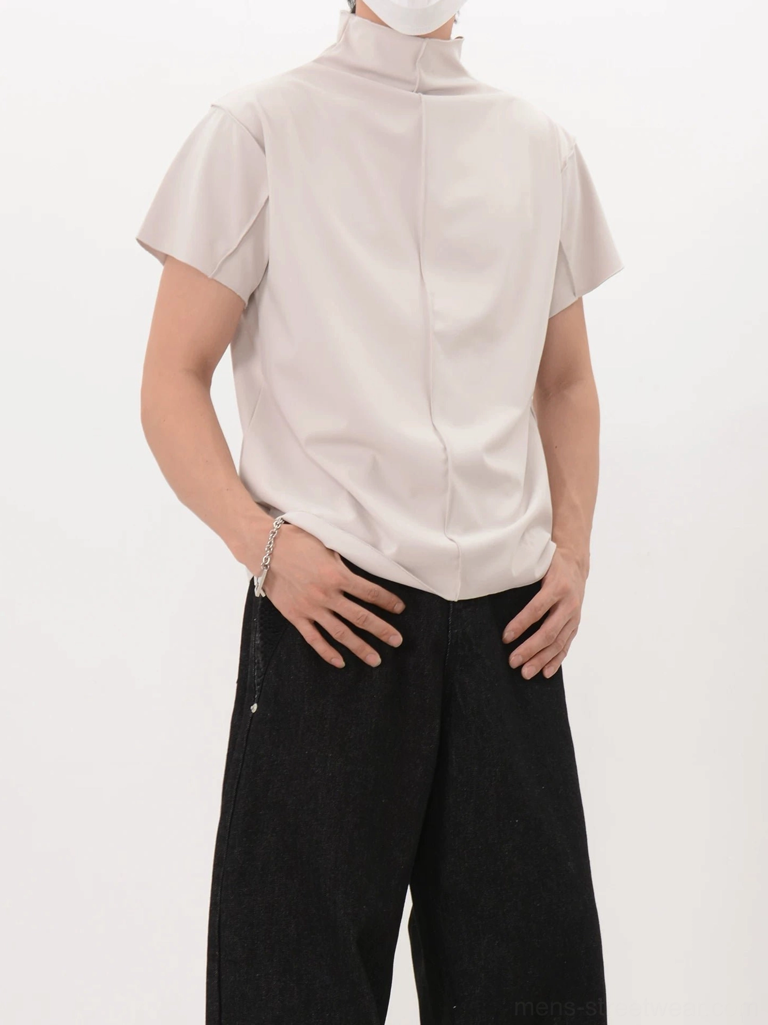 Light beige apricot back seam mock neck short-sleeve shirt shown from the rear in a clean studio setting