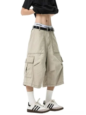 Apricot beige oversized cargo shorts with wide legs and utility flap pockets styled with a cropped streetwear top