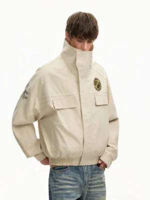 Apricot high collar varsity cargo bomber jacket worn with vintage blue jeans, left front detail view