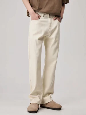 Front full-body view of apricot loose straight leg denim jeans styled with a brown top and casual slides