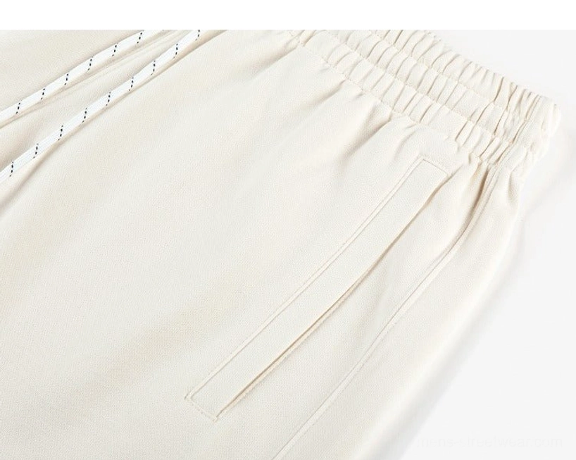 Close-up of apricot oversized sweat shorts showing elastic waistband striped drawstring side pocket and knit fabric
