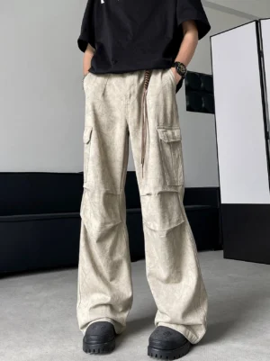Angled front view of apricot wide-leg cargo pants showing oversized side cargo pockets faded washed texture and full-length streetwear silhouette