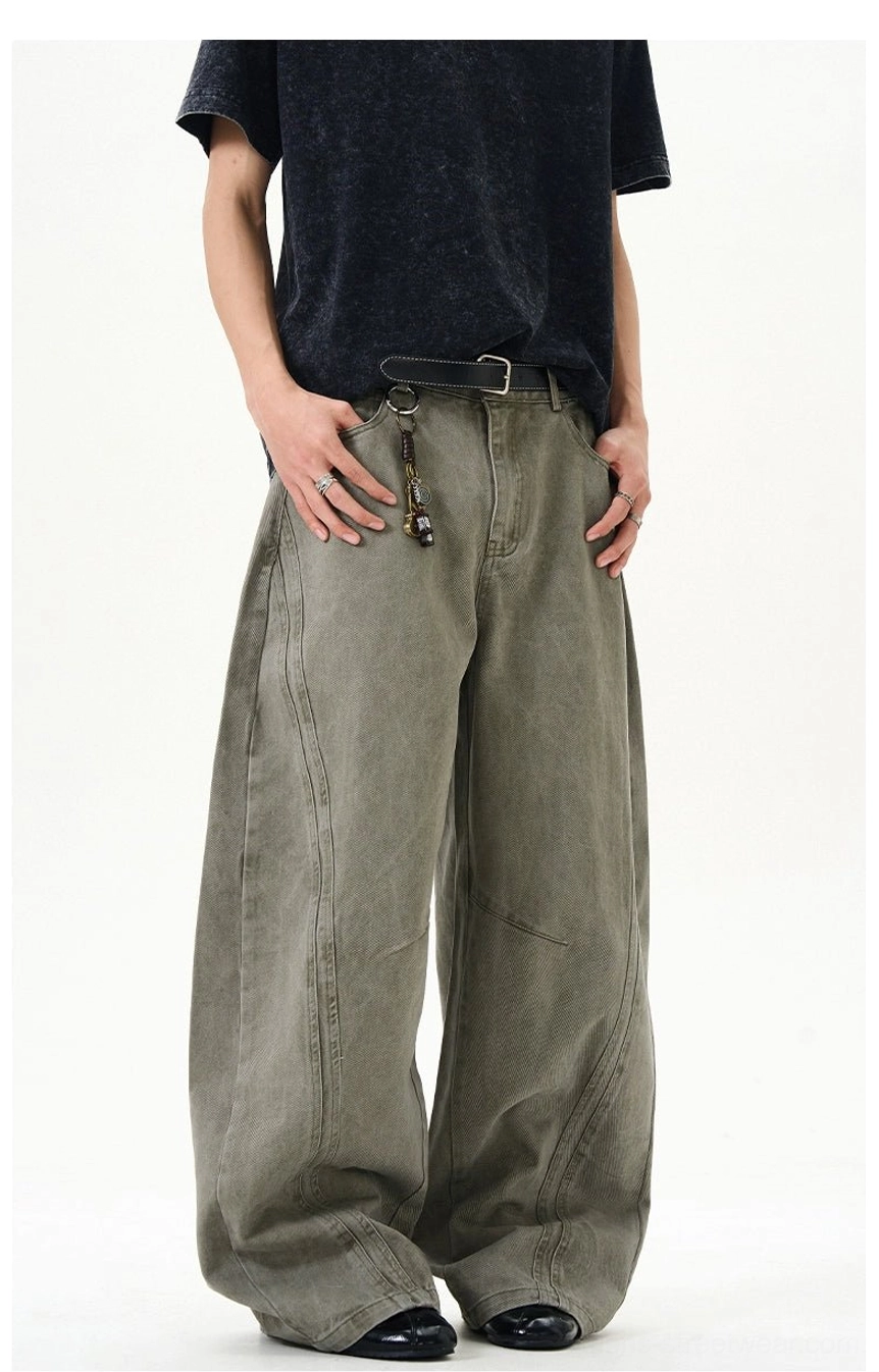 Cement ash ultra-wide washed denim jeans close front view highlighting curved panel stitching and oversized silhouette