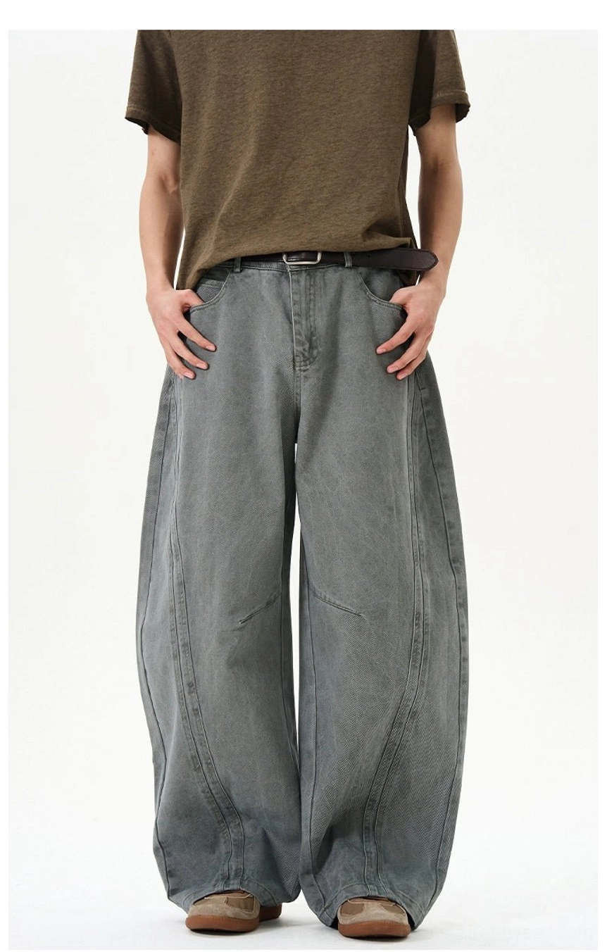Bluish gray green oversized barrel leg jeans with curved seam construction and faded washed denim texture