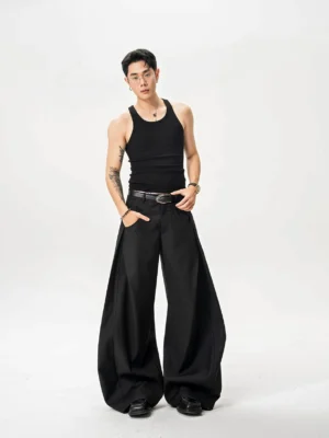 Black ultra wide-leg twill trousers worn by male model with black tank top in white studio front full-body view