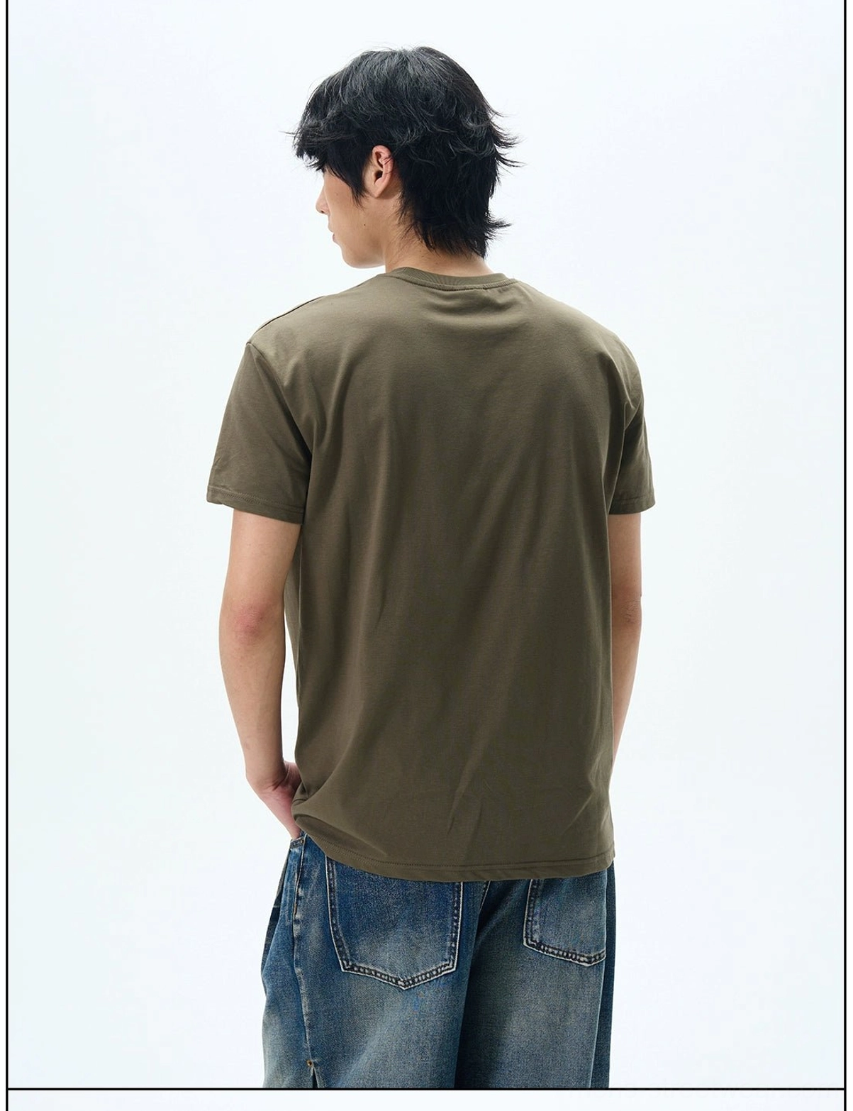 Back view of an army green minimalist crew neck t-shirt worn with wide-leg denim jeans