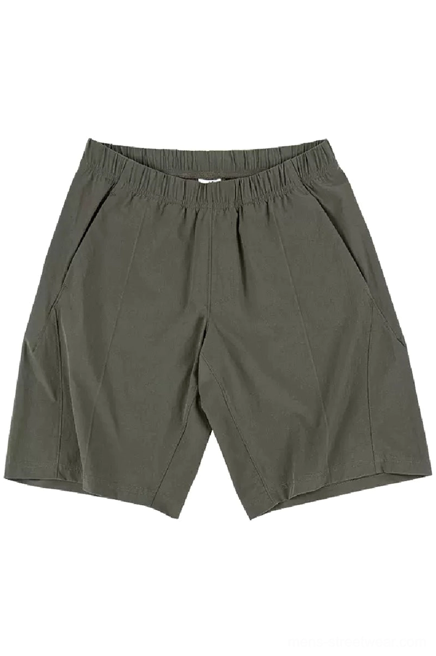 Army green minimalist quick-dry tech shorts front flat lay with elastic waistband and slanted side pockets