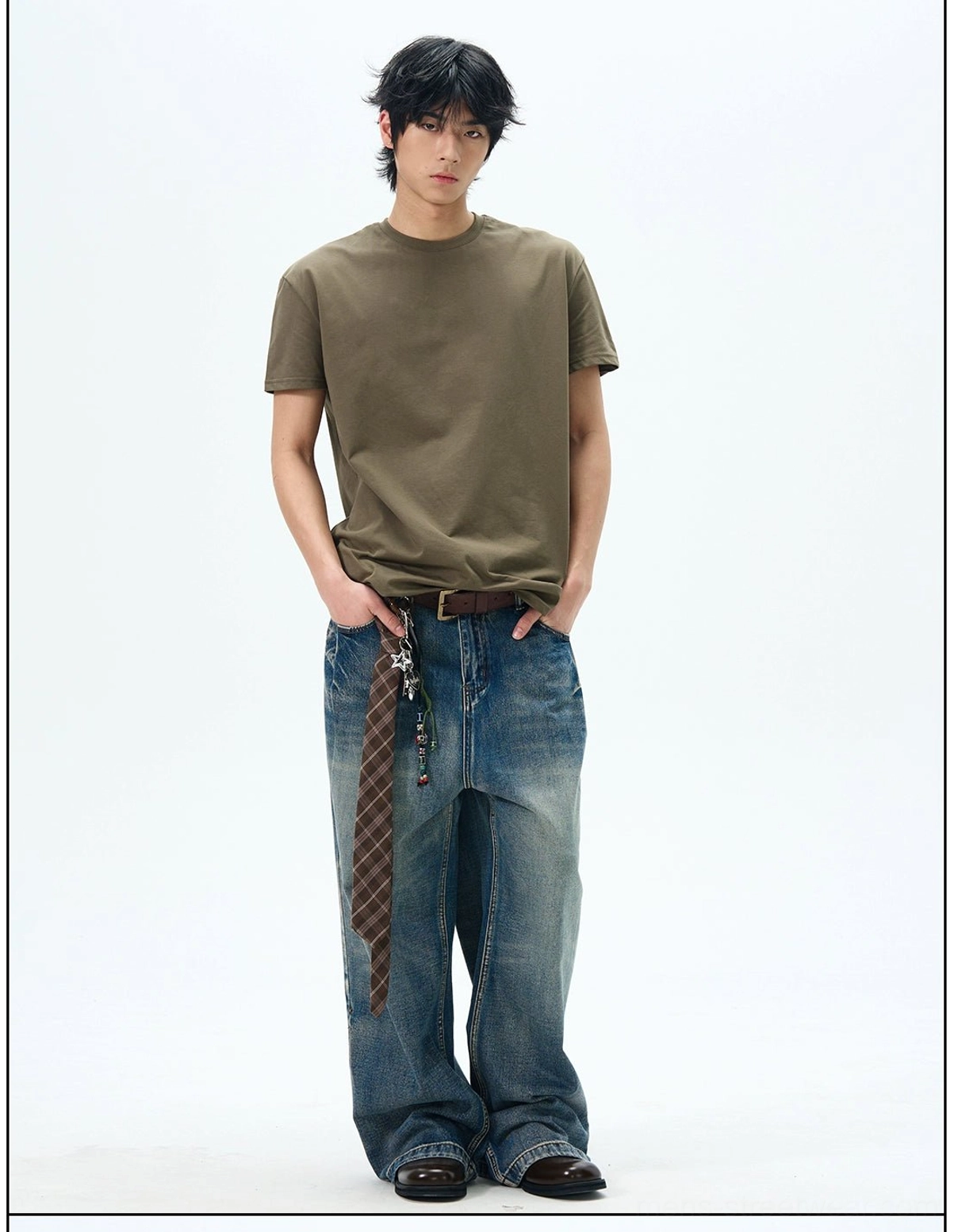 Army green relaxed crew neck t-shirt paired with wide-leg jeans, plaid hanging detail, and brown leather belt