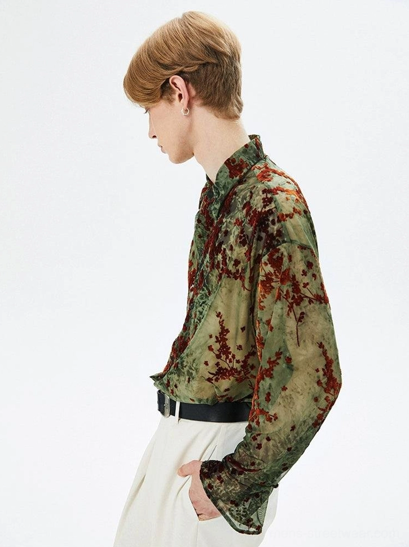 Side profile of male model in relaxed army green semi-sheer botanical print shirt showing long sleeves and flared cuffs