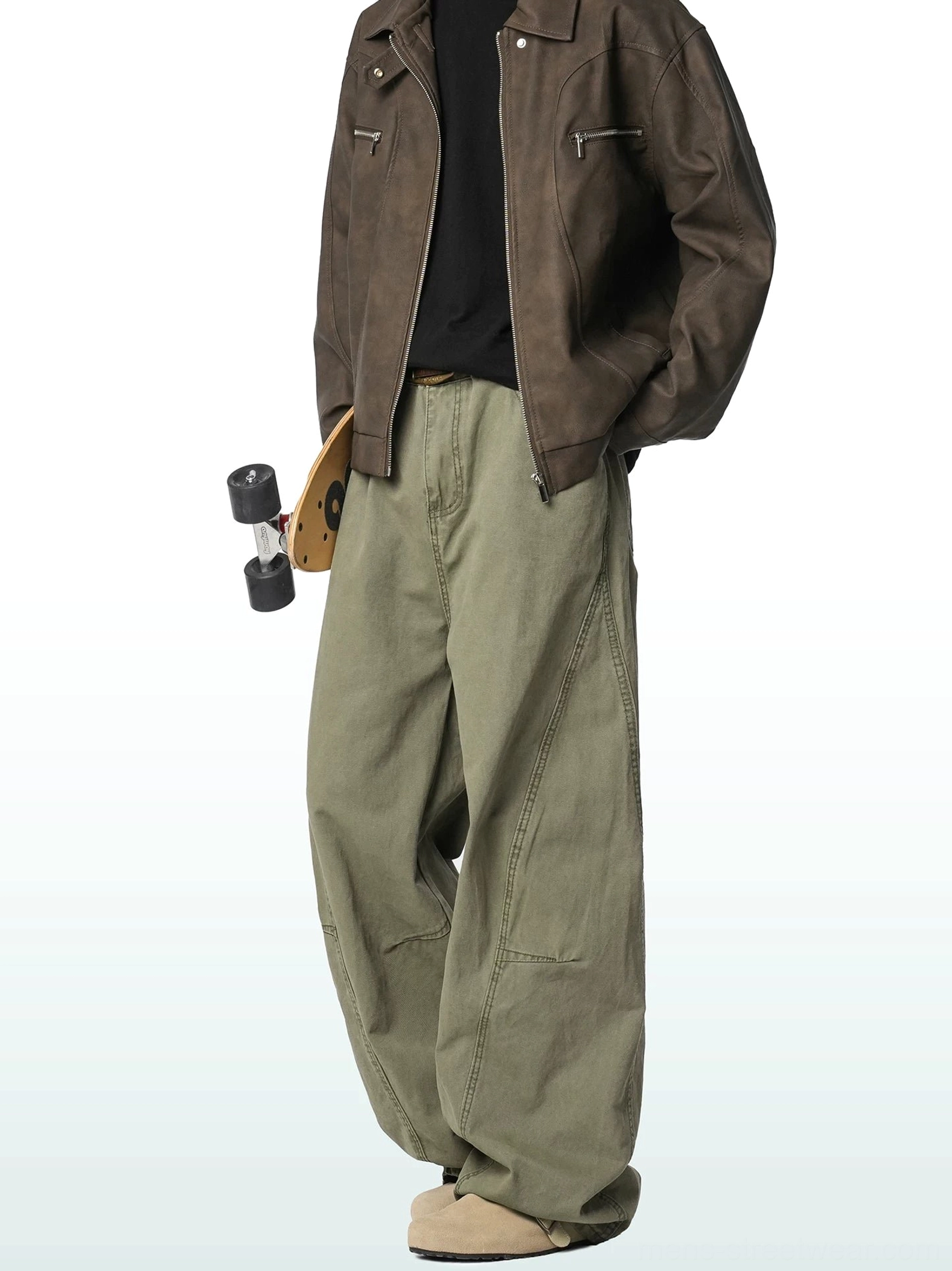 Army green wide-leg cargo trousers shown in side three-quarter view with a skateboard, highlighting structured leg seams and a loose utility-inspired fit