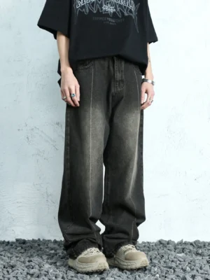 Front full-body view of ash fade washed black wide leg jeans styled with a black graphic T-shirt and chunky sneakers in a contemporary streetwear setting