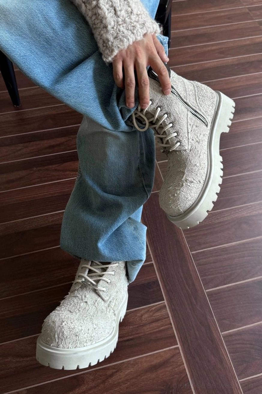 Ash off-white suede lace-up lug-sole boots with side zipper, styled with light blue denim jeans and a fuzzy knit cuff