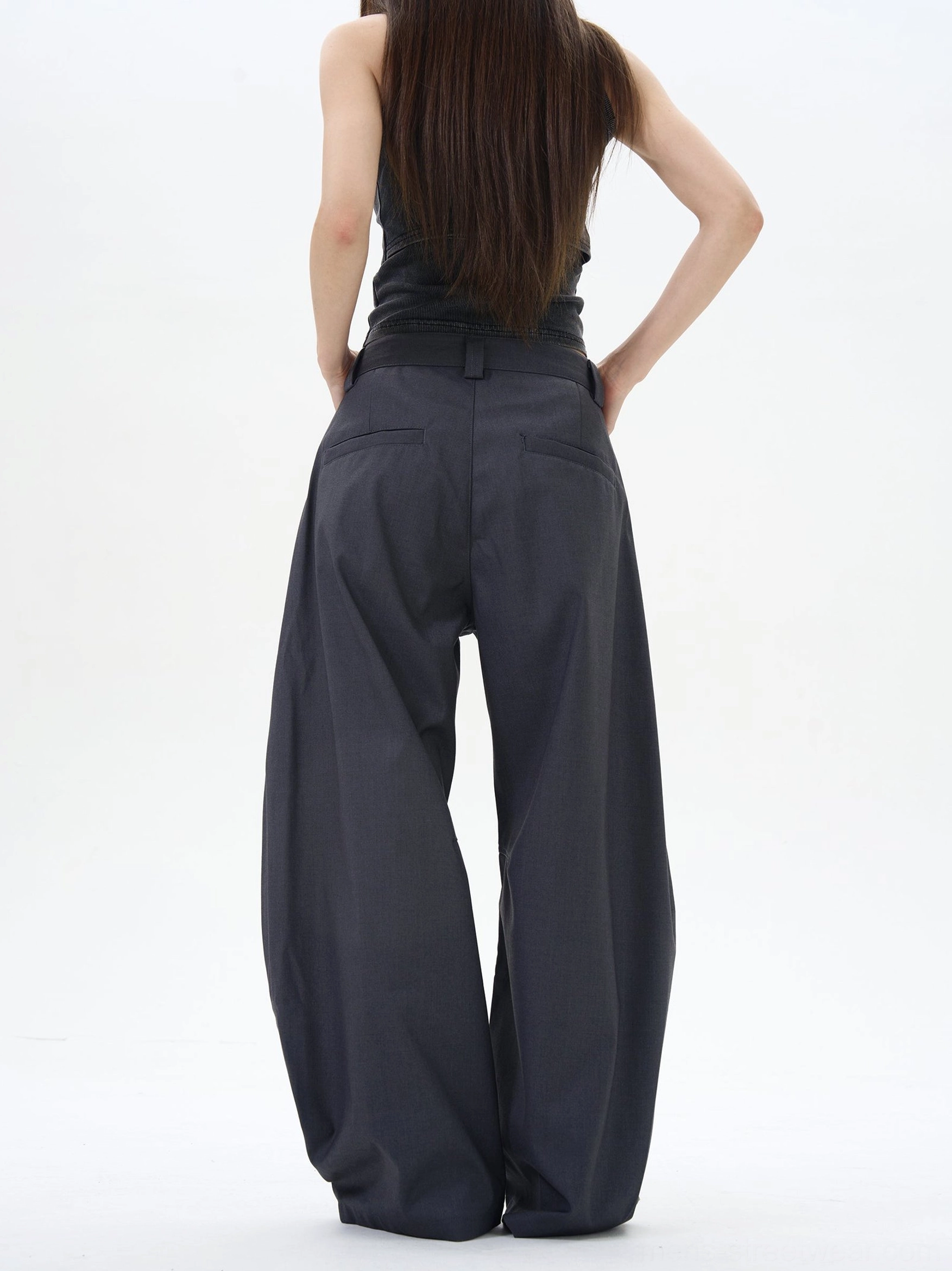 Rear view of dark ash wide-leg palazzo trousers with tailored back pockets and a smooth high-waisted fit in modern Seoul-inspired style