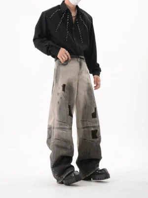 Front view of Ashfall black distressed wide leg jeans with faded grey gradient wash ripped patches and stacked hem