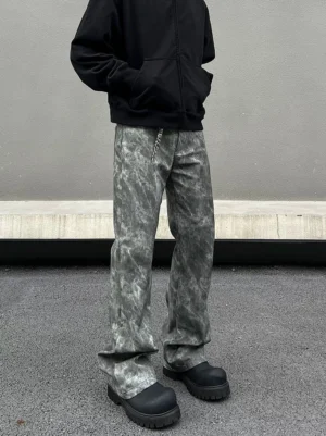 Close front view of grey acid wash flared jeans with relaxed wide leg fit and stacked hem over black platform shoes