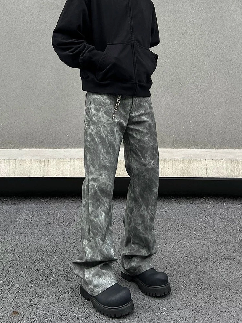 Close front view of grey acid wash flared jeans with relaxed wide leg fit and stacked hem over black platform shoes