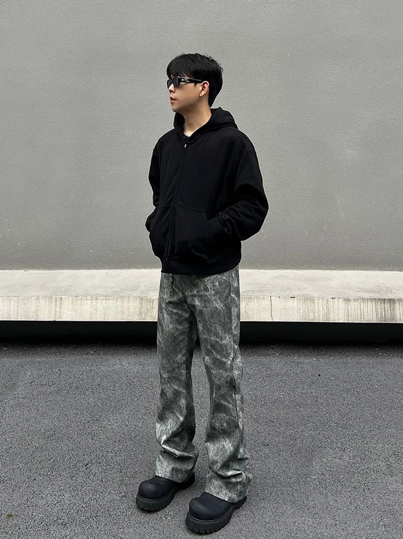 Full side profile of grey marble wash flared jeans in a Korean streetwear outfit with black hoodie sunglasses and platform shoes