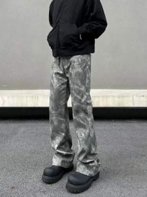 Front full-body view of Ashstorm grey marble wash flared streetwear jeans styled with a black zip hoodie and chunky platform shoes