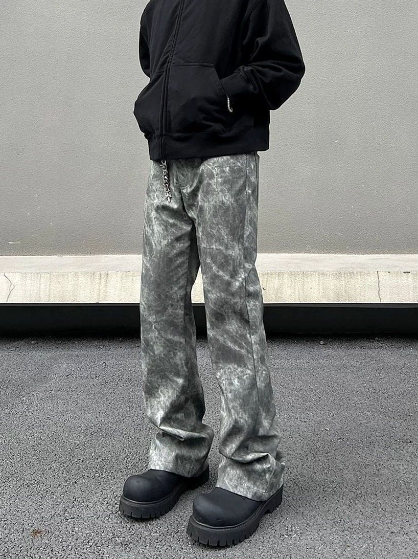 Front full-body view of Ashstorm grey marble wash flared streetwear jeans styled with a black zip hoodie and chunky platform shoes