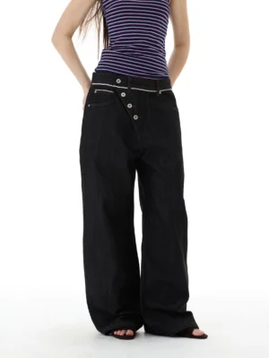 Front full-body view of oversized asymmetric button wide-leg black jeans with contrast stitching and dark denim streetwear styling